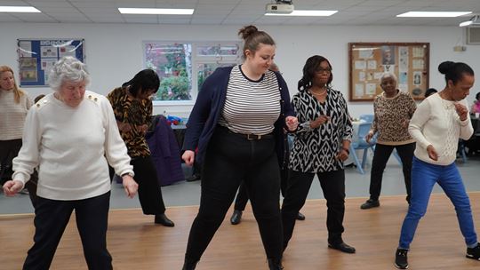 Residents stood in line formations dancing with an guide