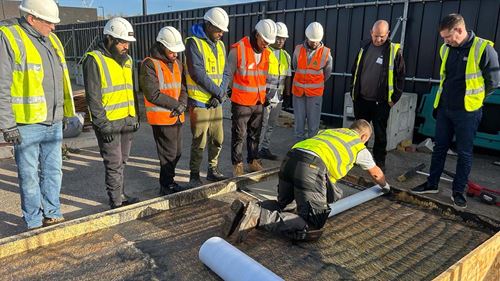  Participants observe a roofing demonstration during Bauder’s hands-on workshop in London.