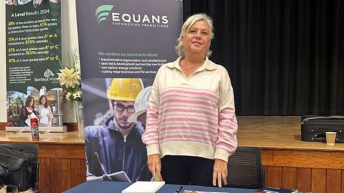 Karen Field, Social Value Manager at Equans stood at fair stand with leaflets on the table