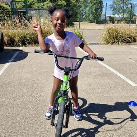 A young girl on a green bike