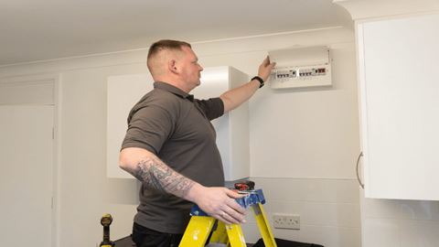 A man looking at an electric switch board