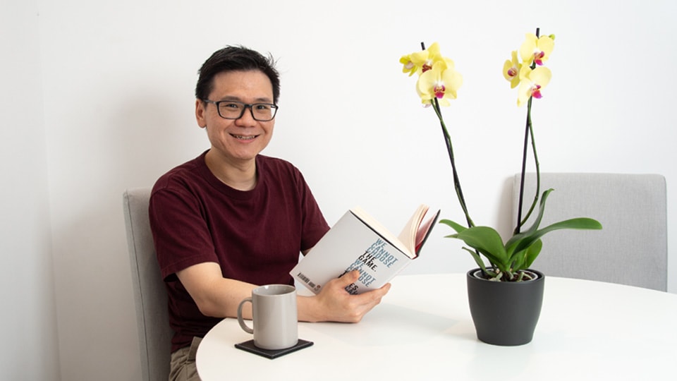 Man sat at table with flower on it